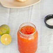 Orange papaya jam in a glass jar.