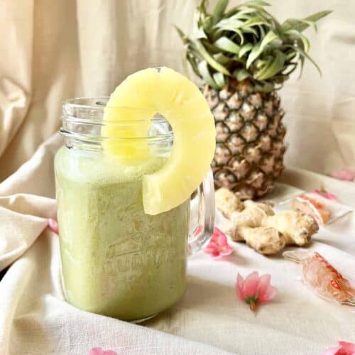 A glass of matcha coconut latte with pineapple.