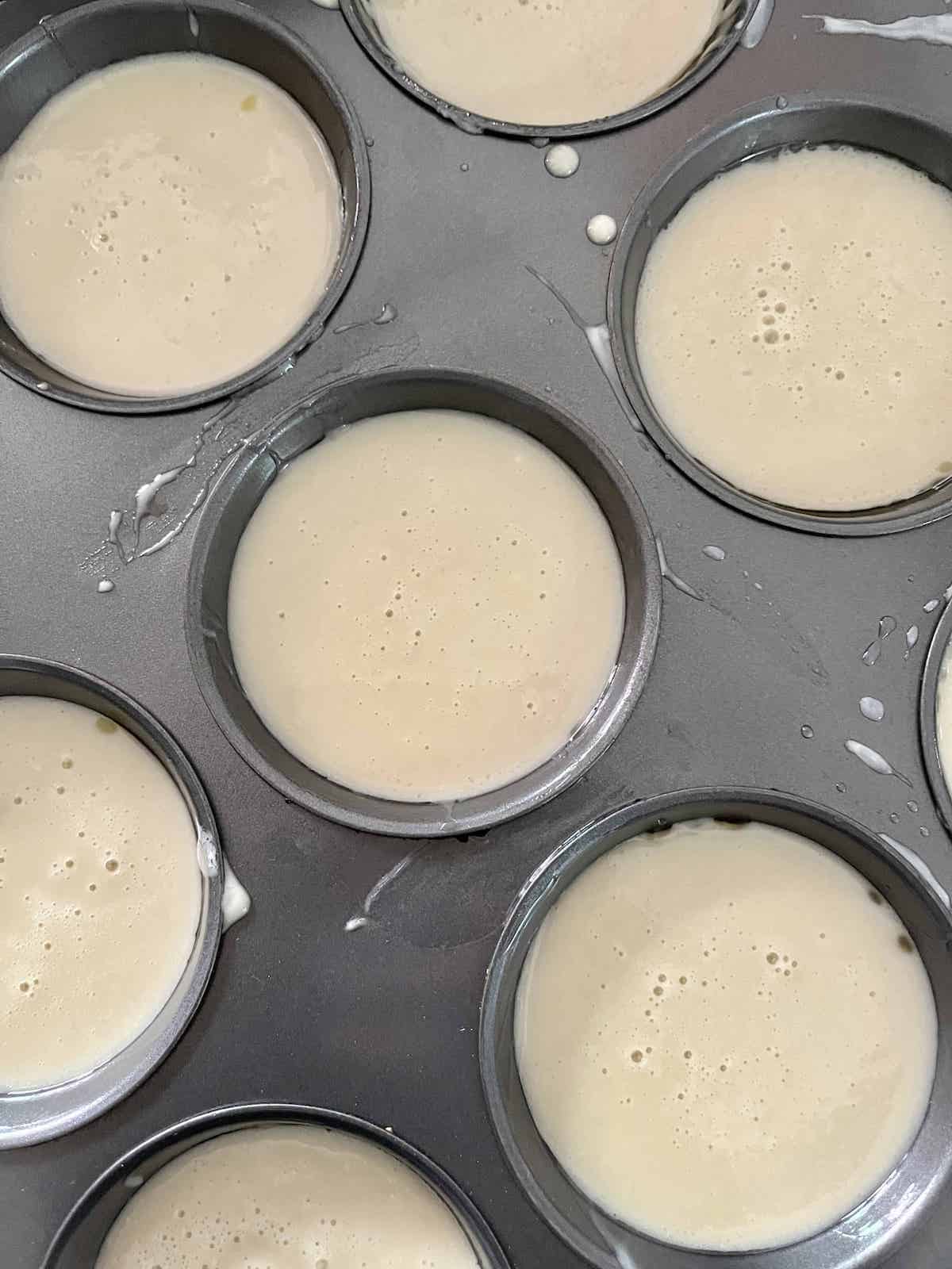 A muffin tray filled with Hojicha mochi muffin batter.