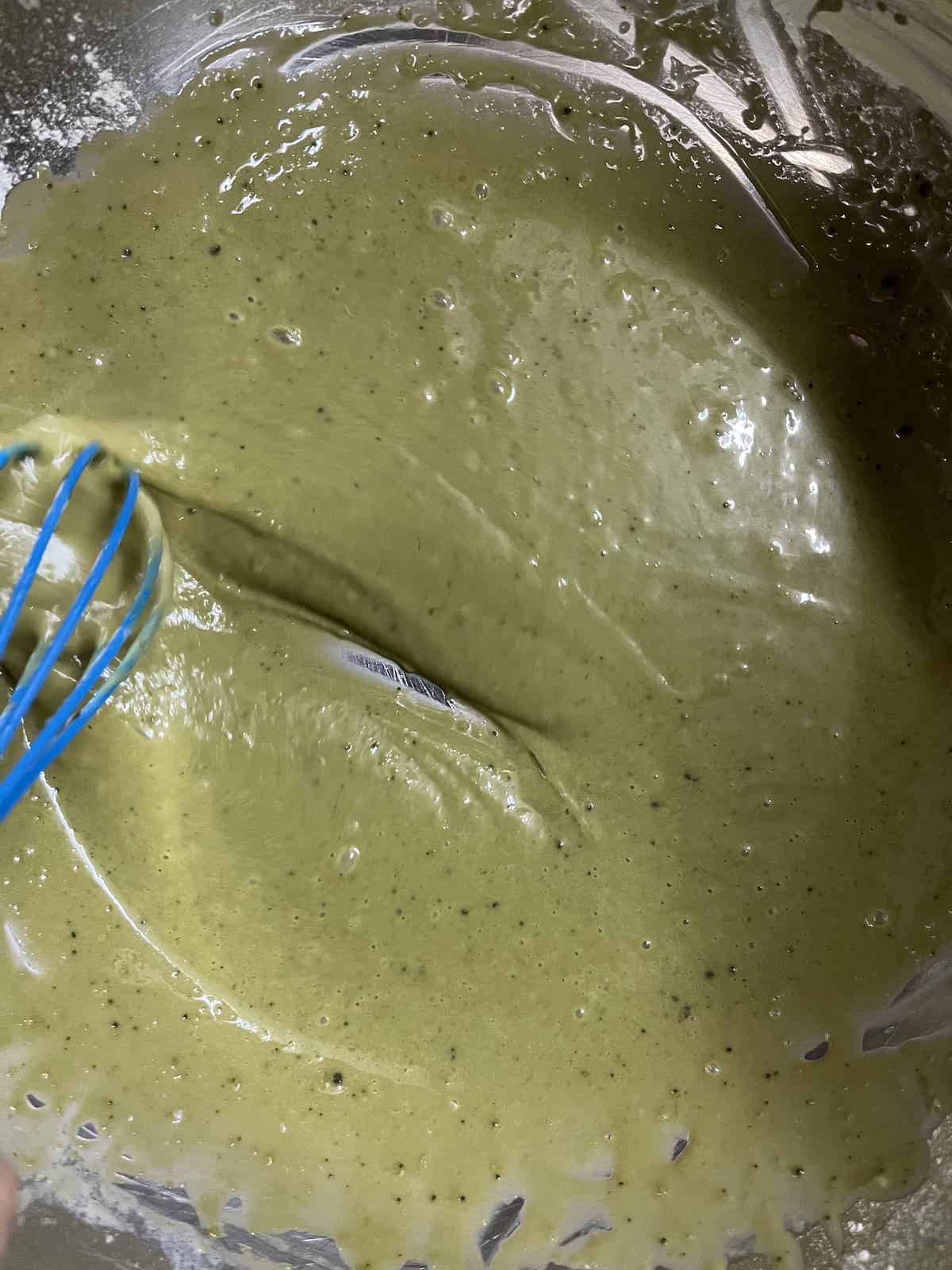 Green matcha mochi muffin batter in a steel bowl.