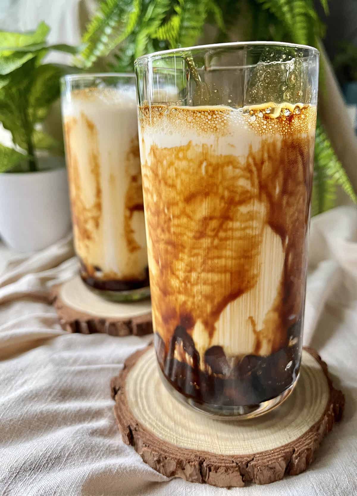 2 glasses of homemade Taiwanese tiger milk tea with brown sugar streaks on the glass.