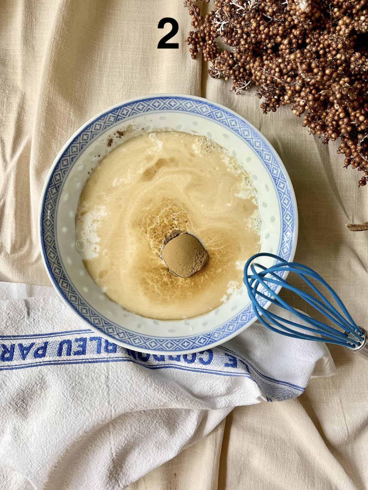 Whisking hojicha powder into a bowl of milk.