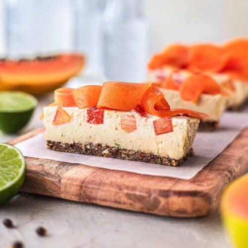 A side view of papaya lime bars on a wooden platter.