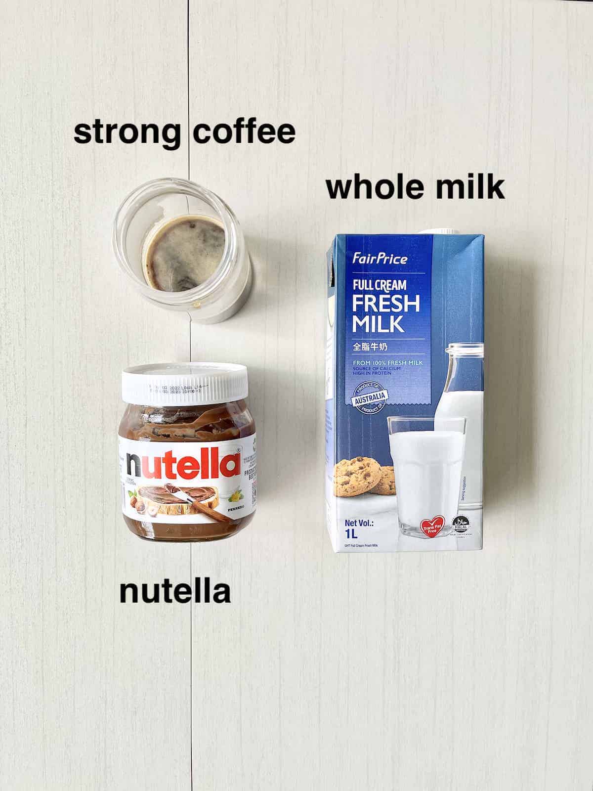 A bottle of nutella, a cup of coffe and milk next to each other. 