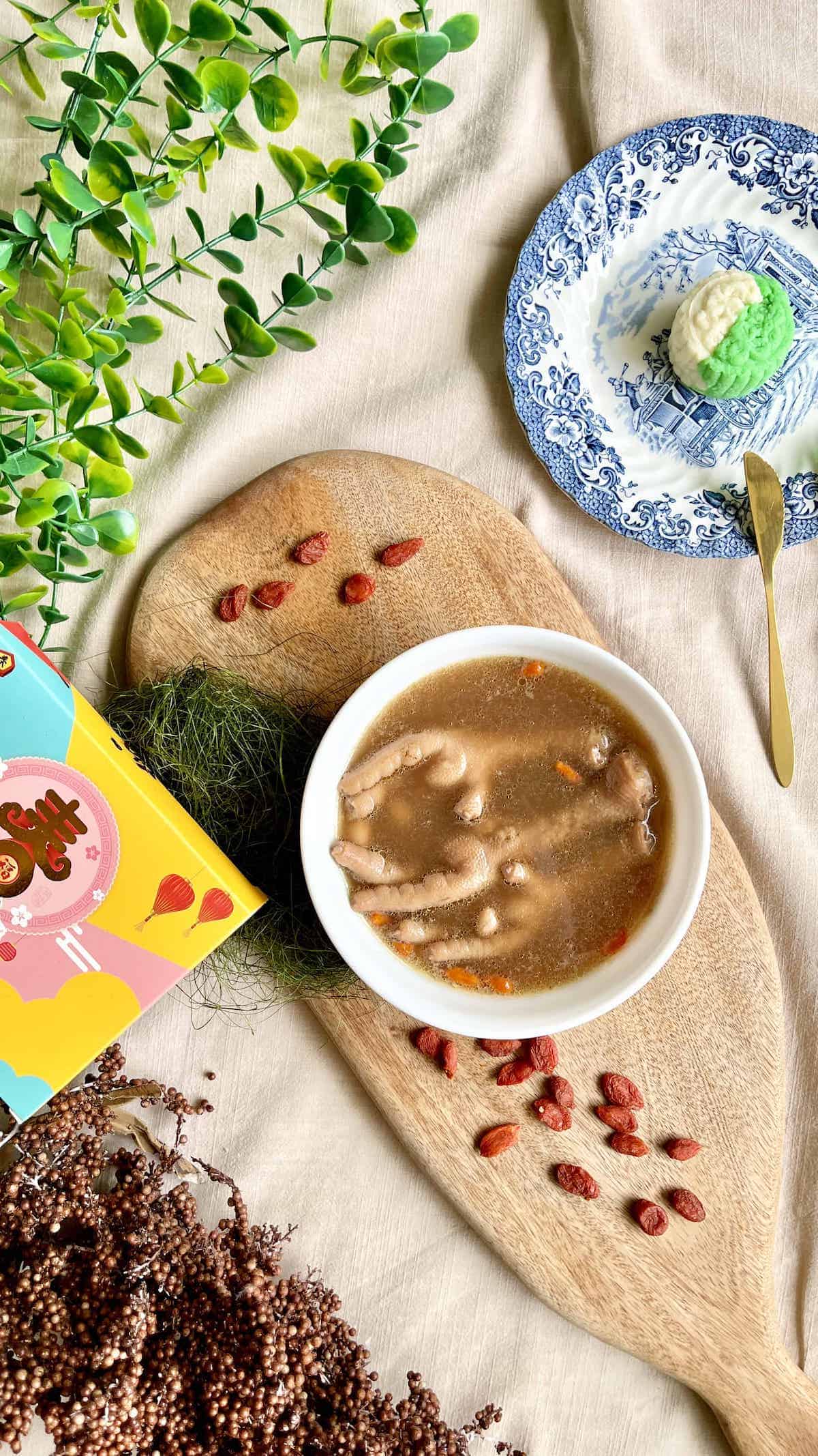 A bowl of Chicken Foot Soup next to a Mooncake and wolfberries.