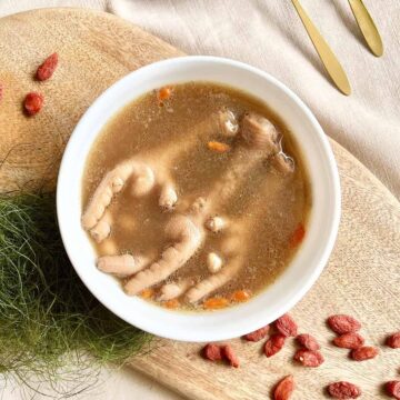 A bowl of Chinese chicken feet soup with peanuts and goji berries.