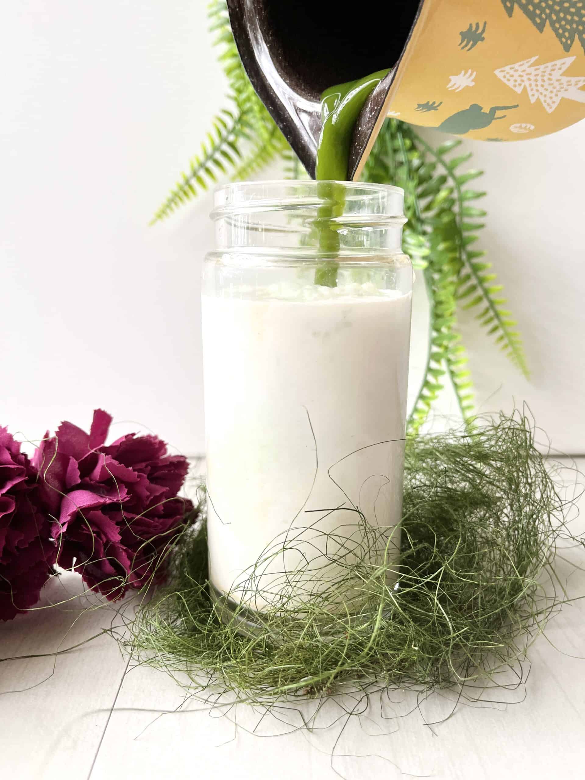 Pouring Green Pandan Juice into a glass of cream.