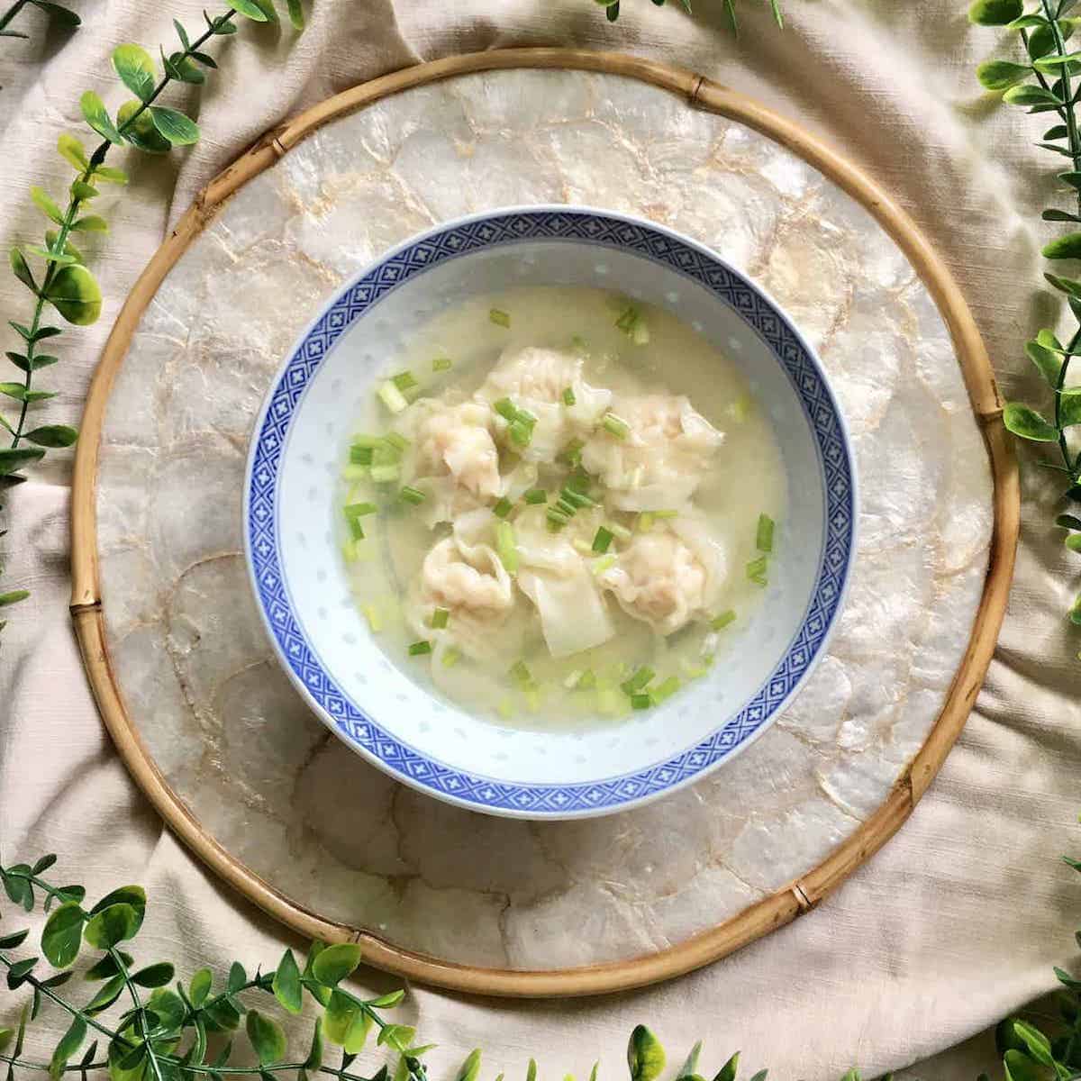 Chinese wontons in a bowl of clear chicken soup.