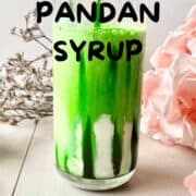 Close-up of a glass of pandan syrup and milk, with text overlay.