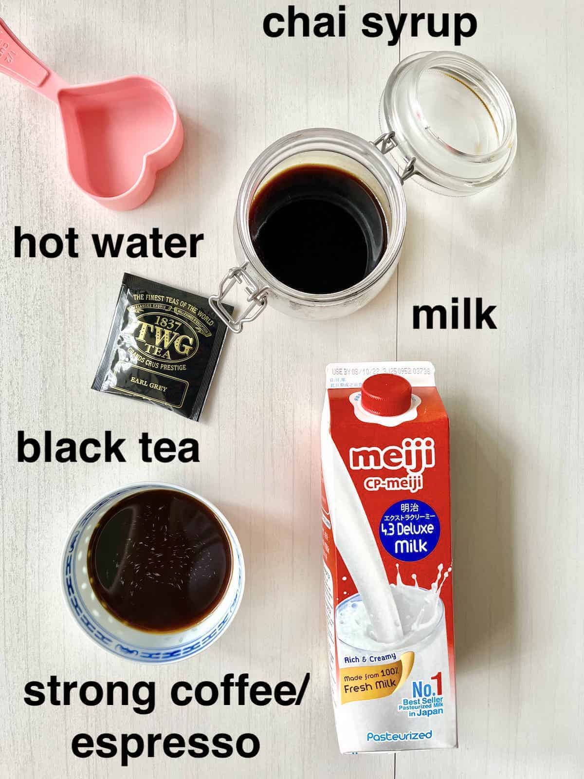 The ingredients for Dirty Chai, including Chai Syrup, on a cream background.