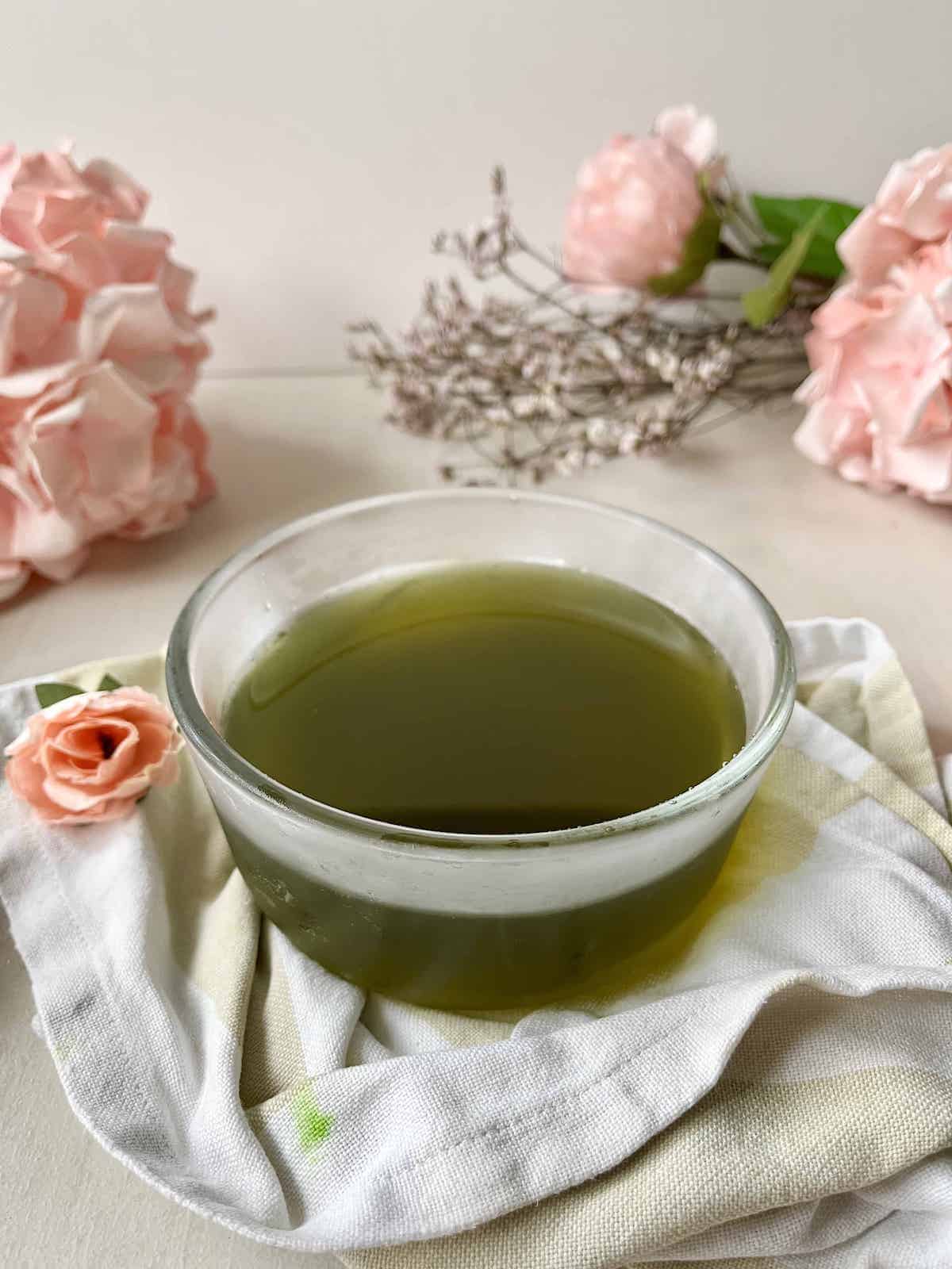 A glass bowl full of vegetal green natural pandan syrup.