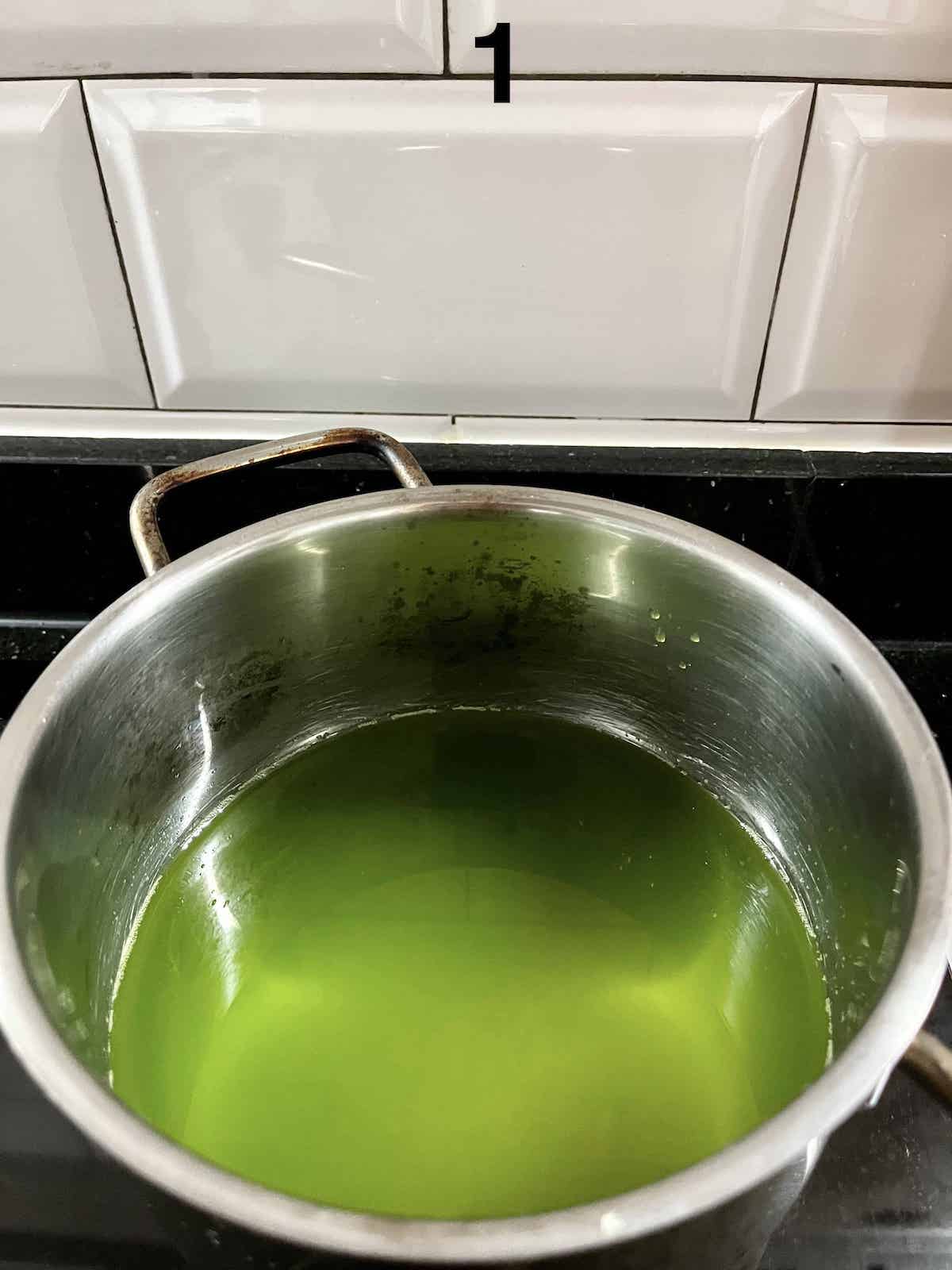 Pandan juice and sugar simmering in a pan.