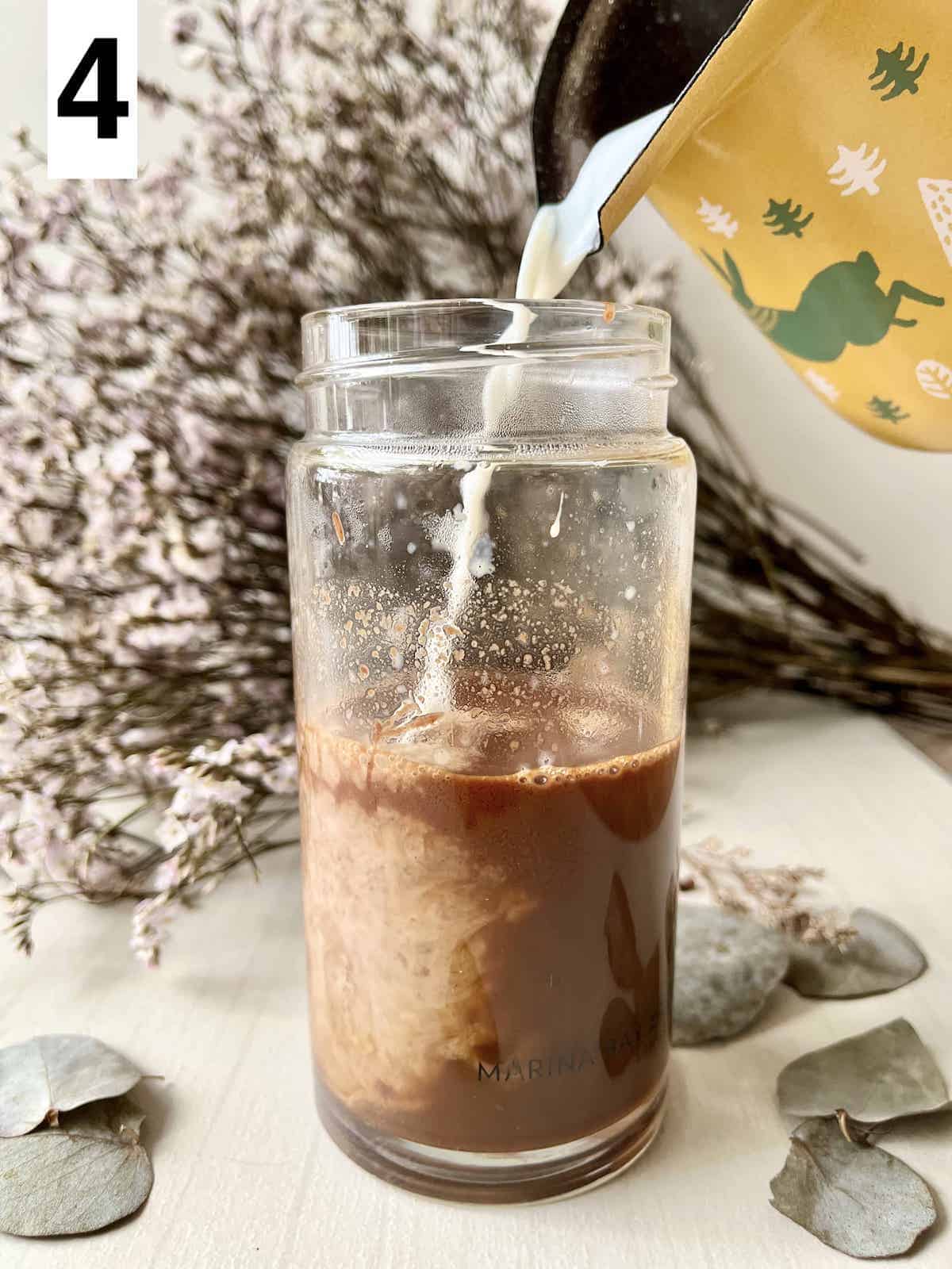 Pouring frothed steamed milk into Nutella Coffee.