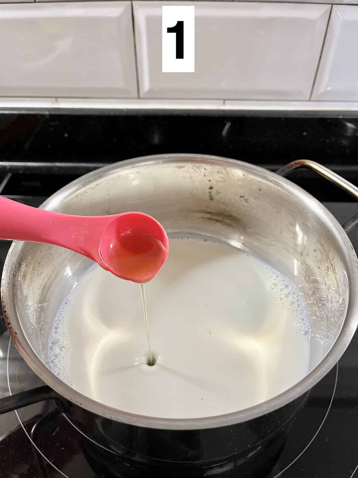 Adding homemade pandan syrup to hot milk.