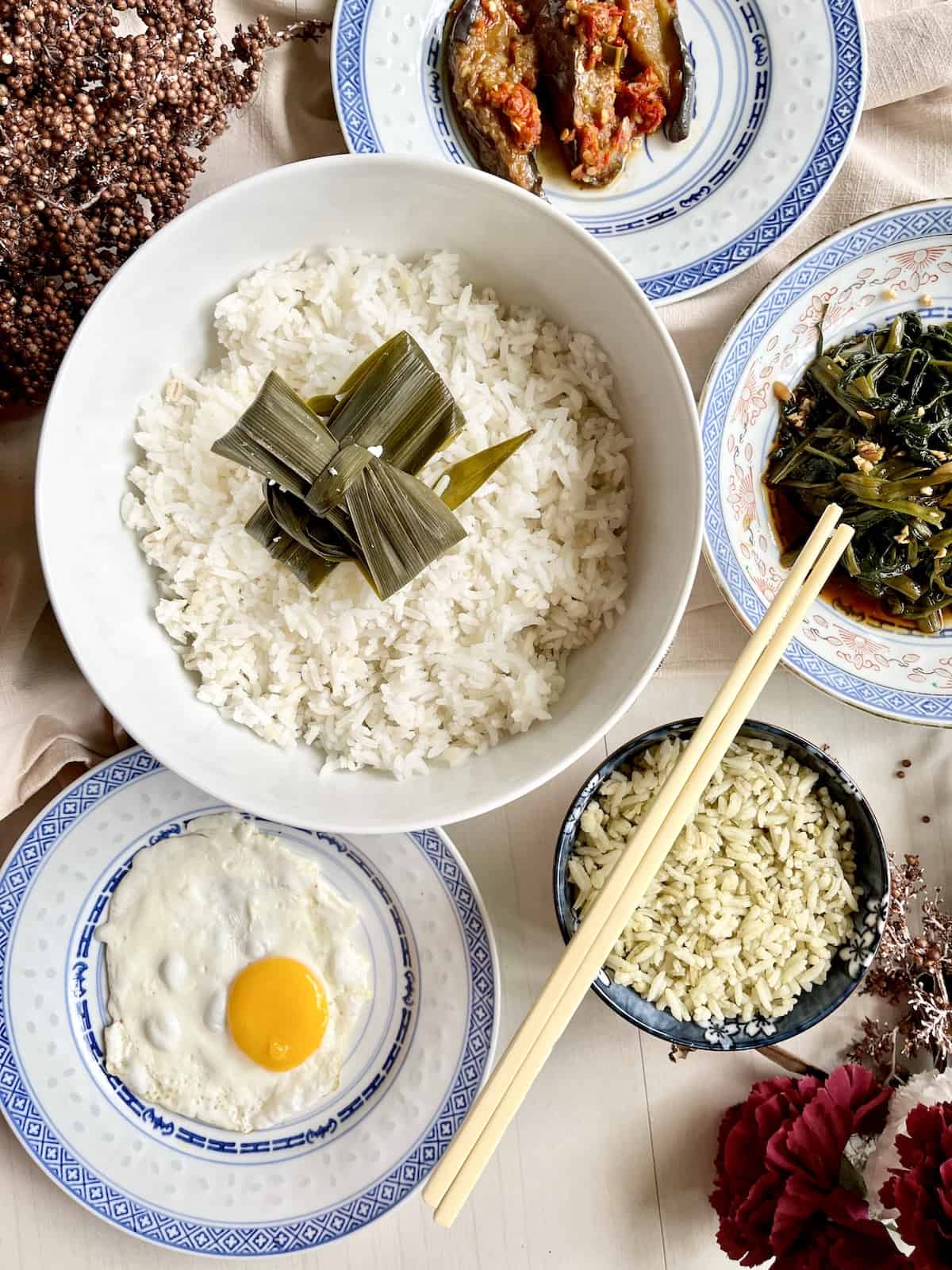 A South East Asian feast of 2 types of pandan rice and other foods.