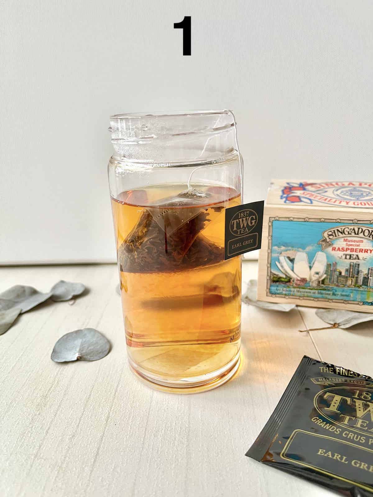 Brewing a cup of black tea in a glass cup.