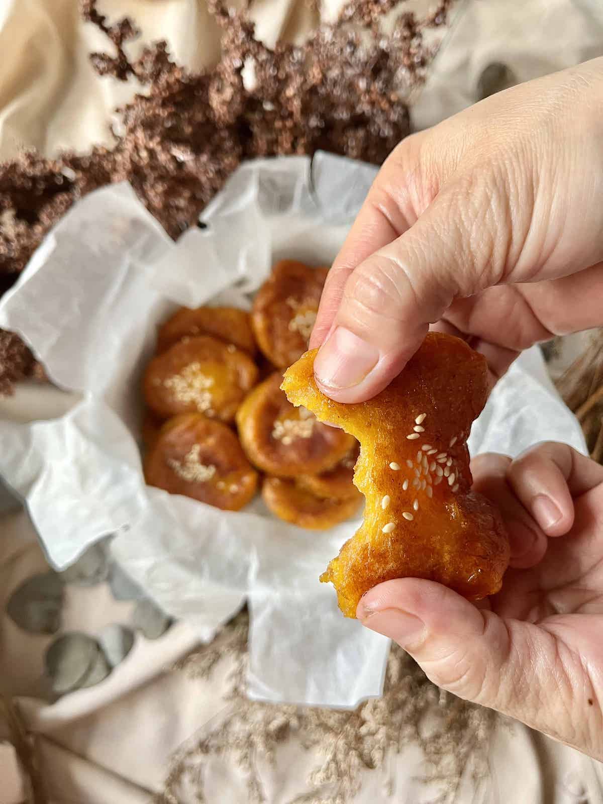 Someone tearing a soft Chinese pumpkin pancake apart.