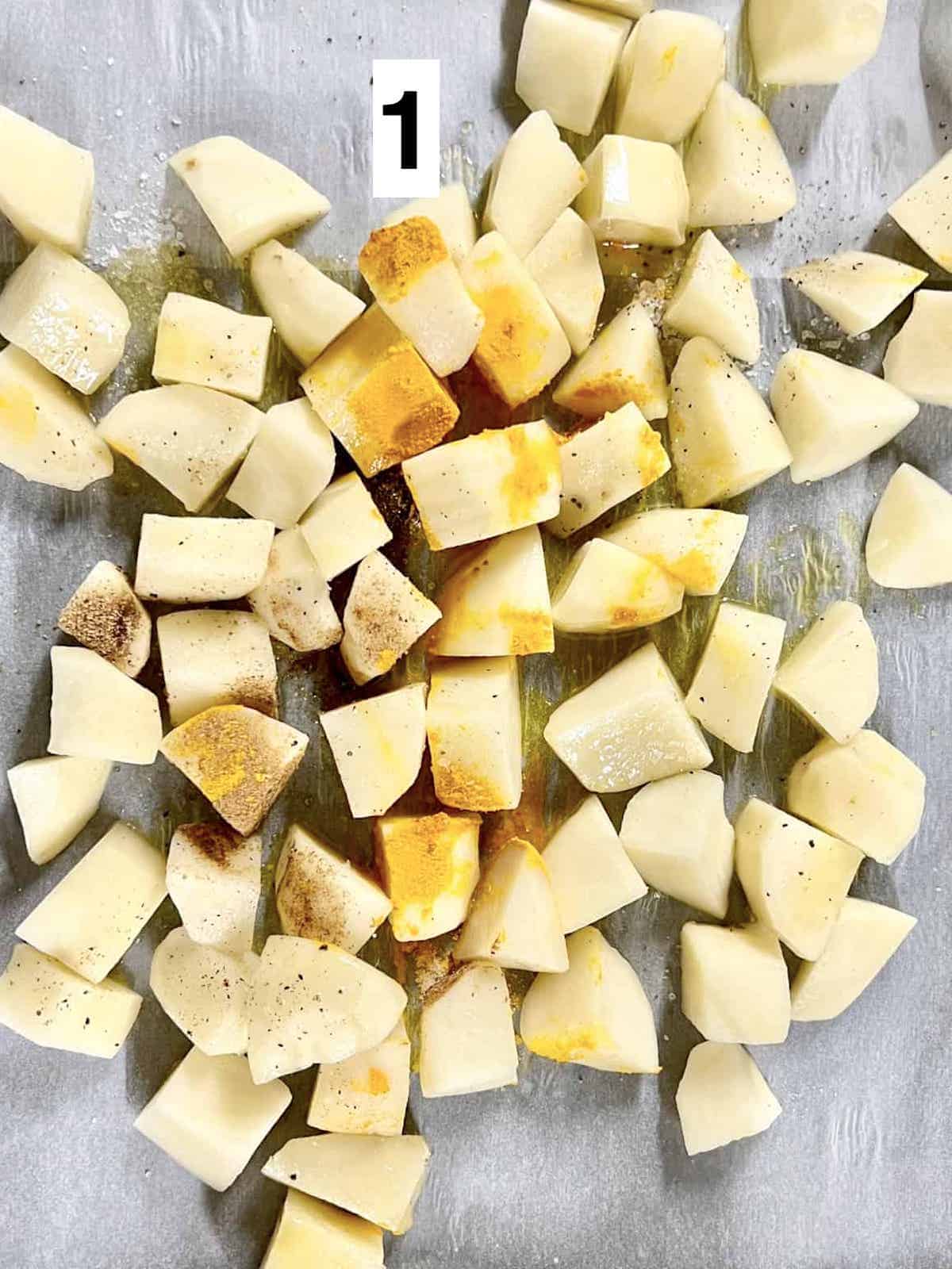 Cut potato cubes with turmeric and garam masala powder on them.