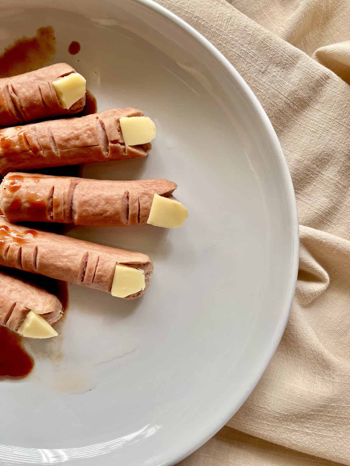 A plate of bloody, wrinkled, severed, Halloween sausage fingers.