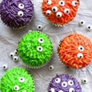 6 colorful monster cupcakes that are green, red and purple.