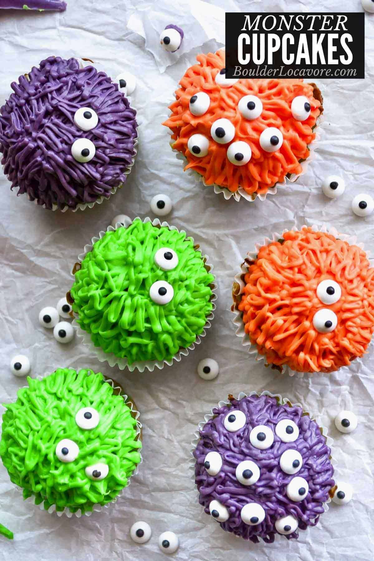 6 colorful monster cupcakes that are green, red and purple.