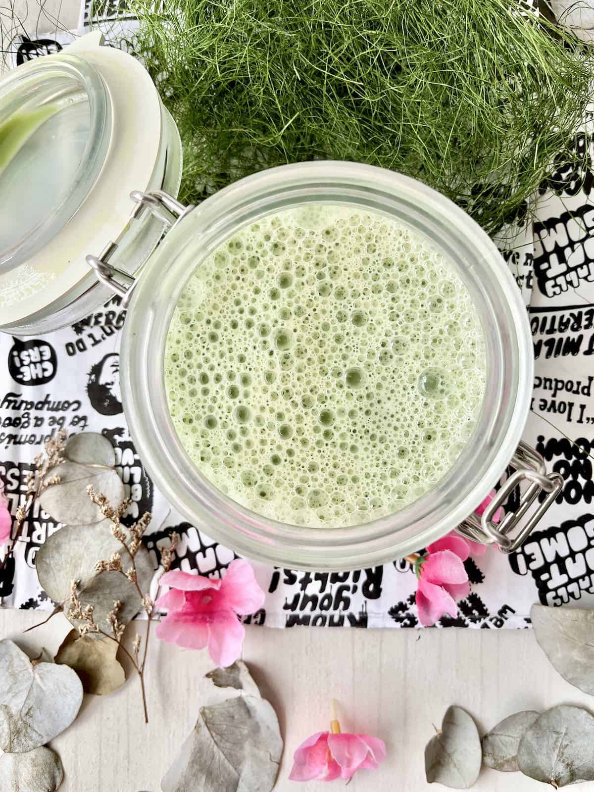 An oat milk matcha latte made in a mason jar that is very frothy!