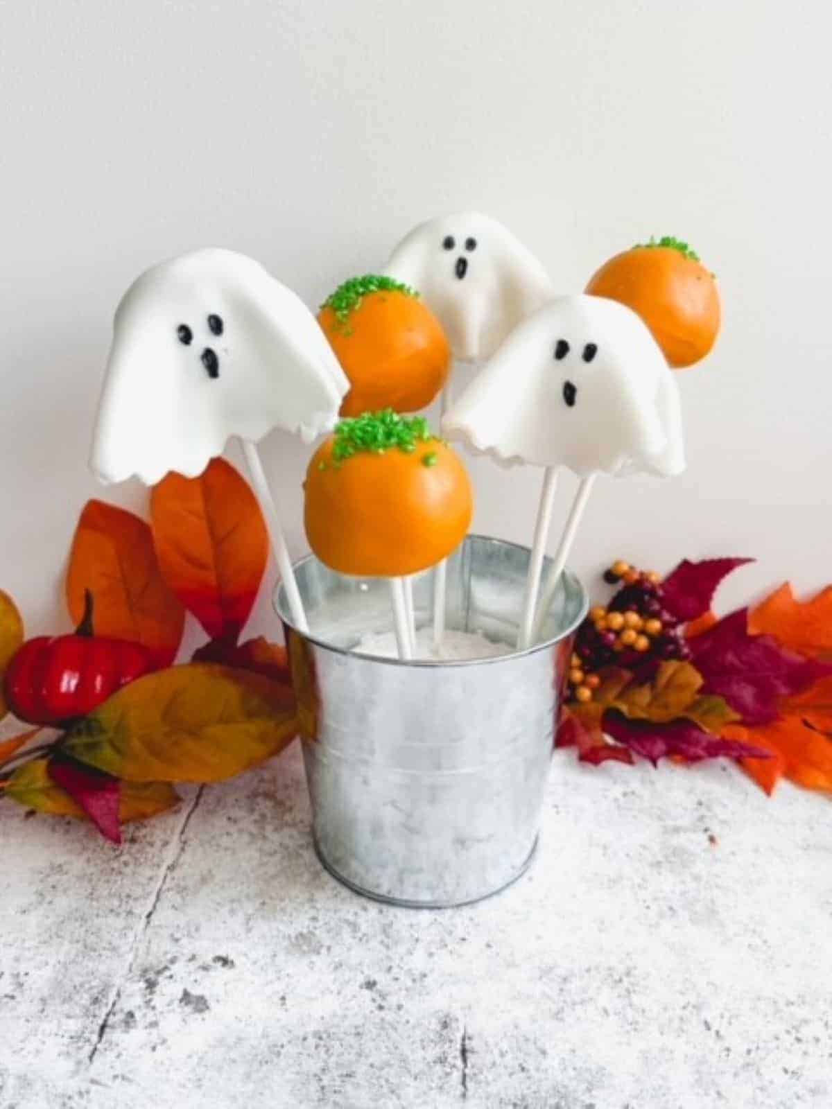 Ghost-shaped cake pops in a small silver bucket.