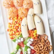 A healthy Halloween fruit platter with bananas and pretzels.