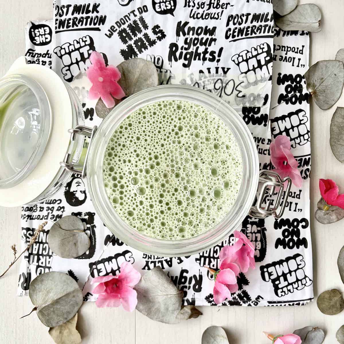 Overhead shot of a green oat milk matcha latte on Oatly paper packaging.