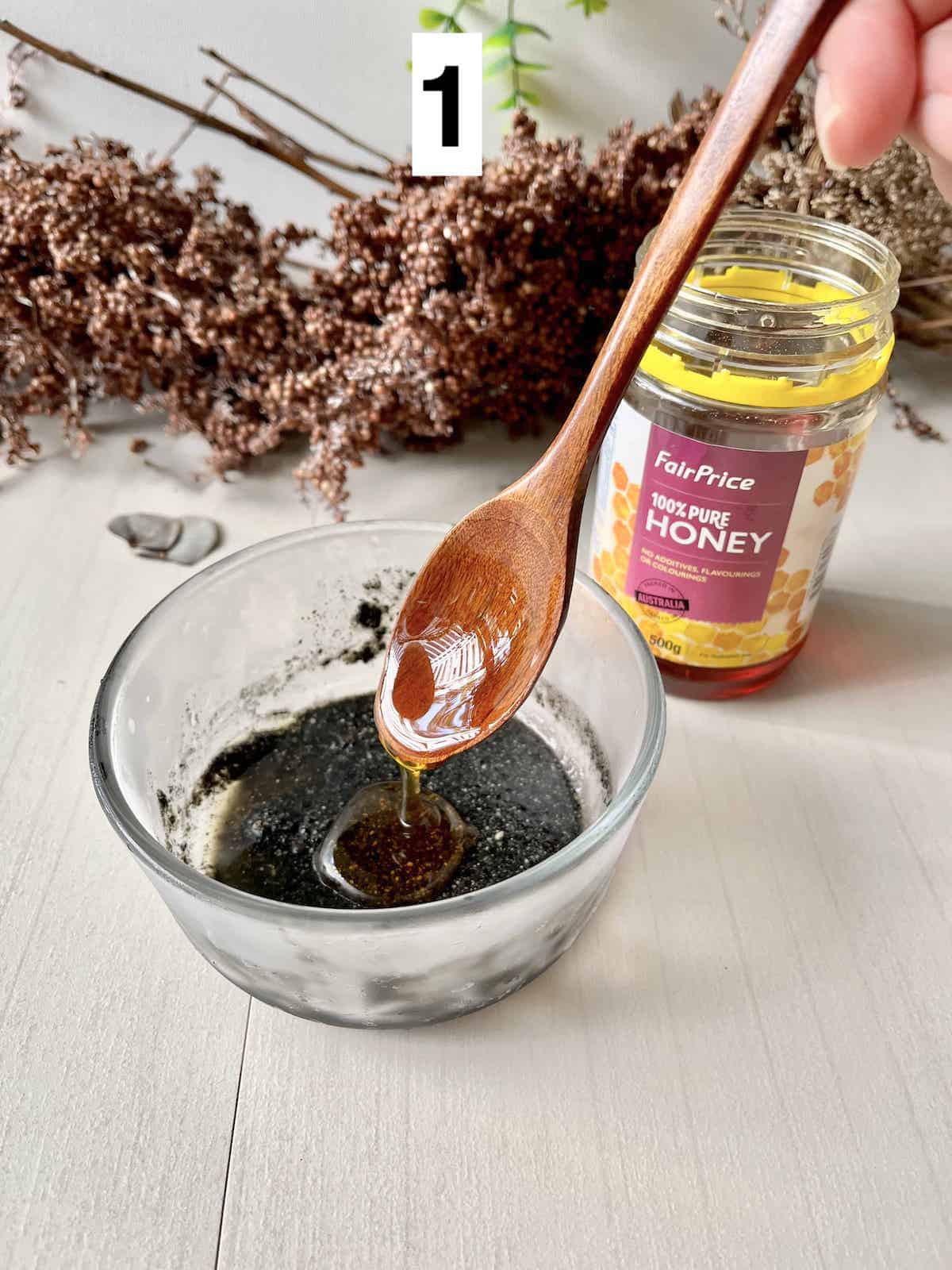 Using a wooden spoon to mix honey into black sesame paste.