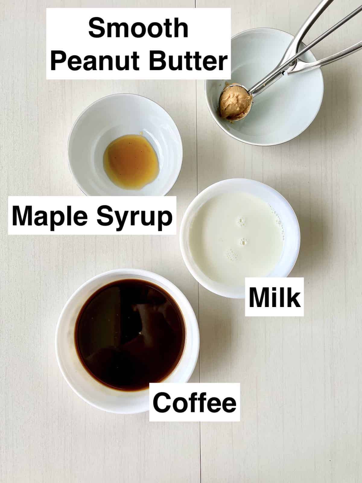 The ingredients for peanut butter in bowls on a white background.