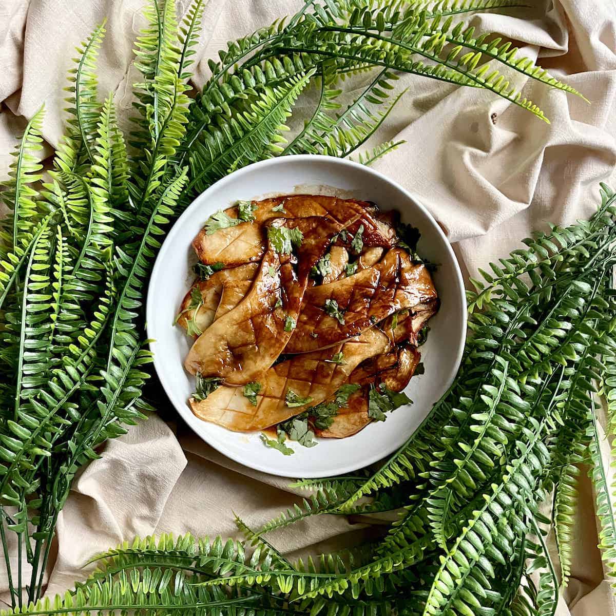 A plate of seared mushrooms tossed in a butter soy sauce.