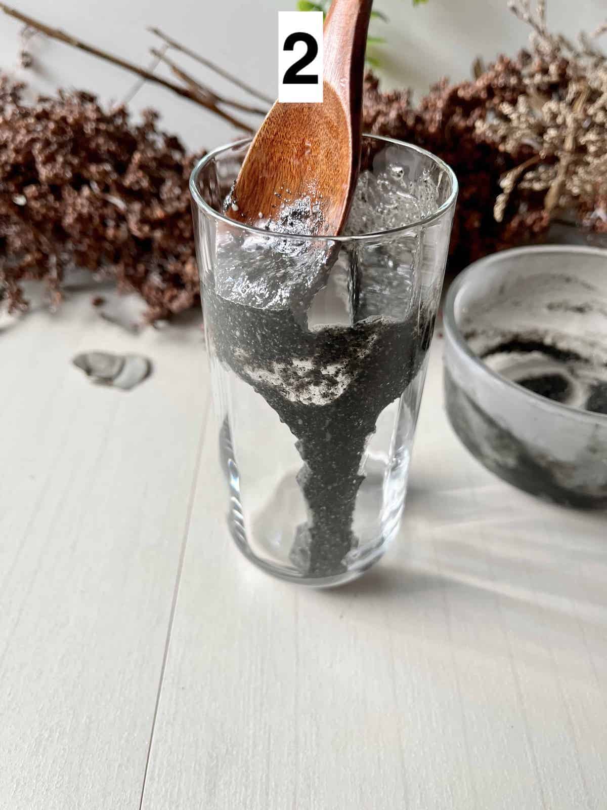 Using a spoon to create pretty black layers on a glass.