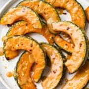 Sliced Kabocha Squash glazed with miso on a white plate.