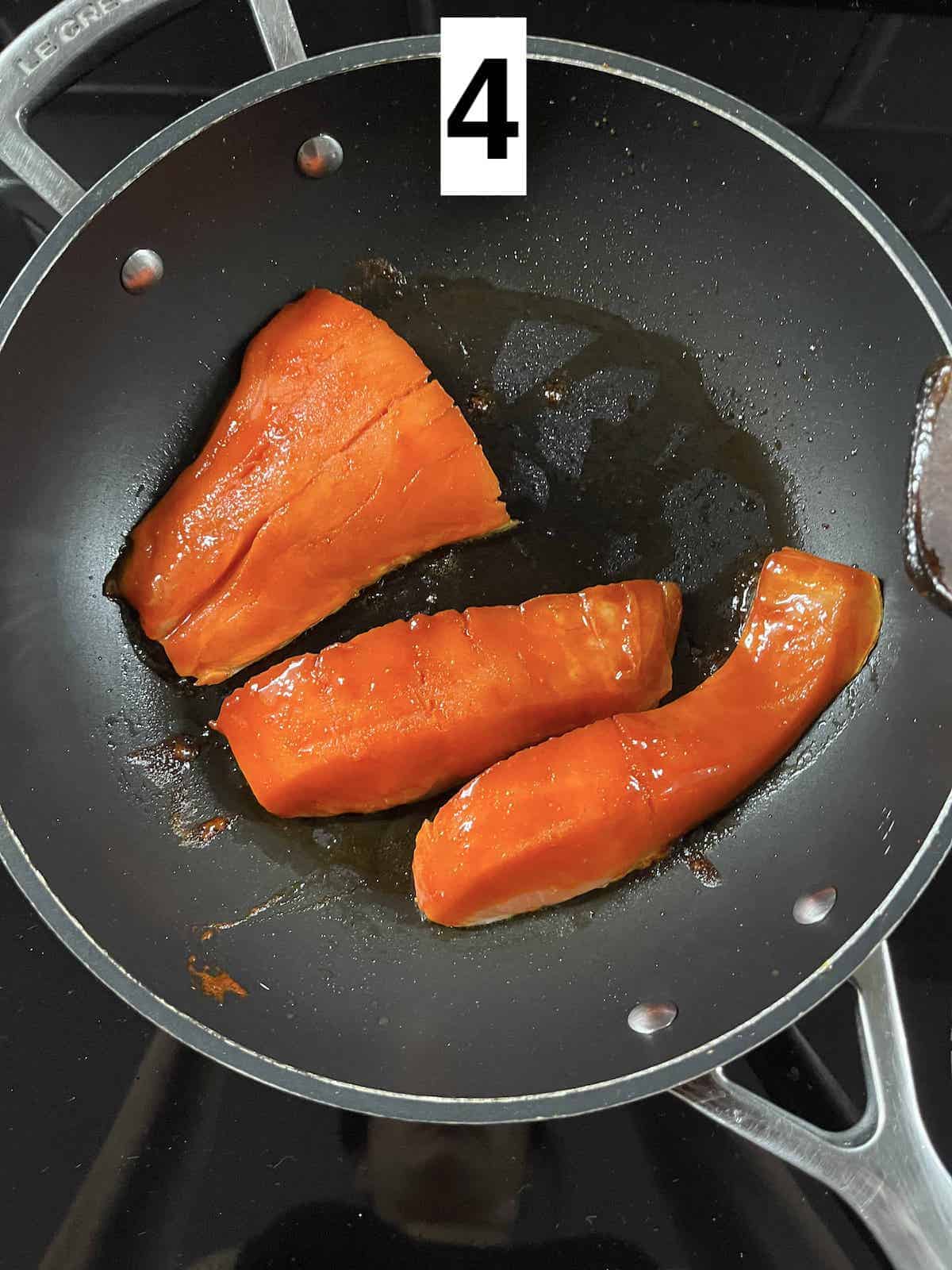 3 salmon fillets in a pan, skin down.