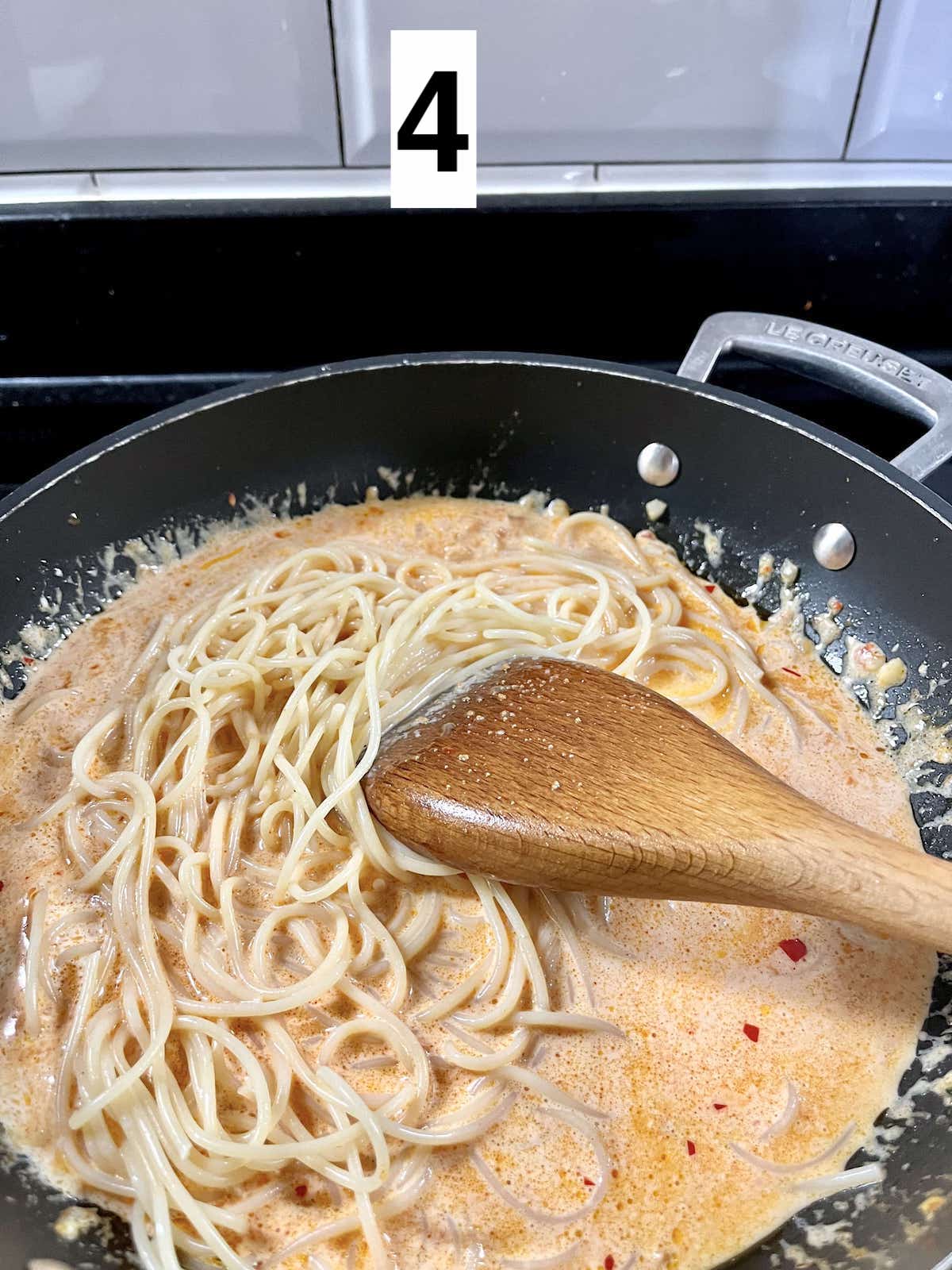 Simmering pasta noodles in gochujang sauce.