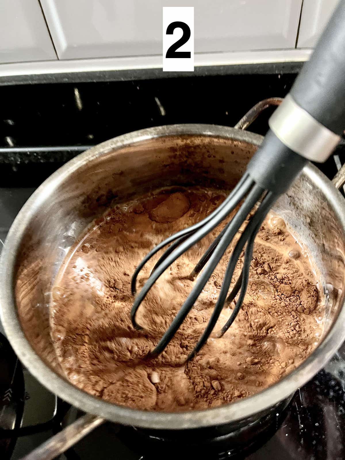 Whisking cocoa powder in milk to remove lumps.