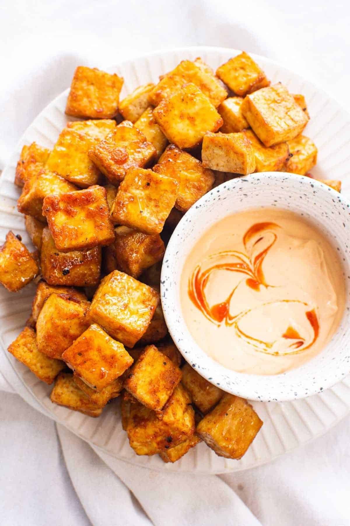 Air Fried Tofu Cubes next to a bowl of sauce.