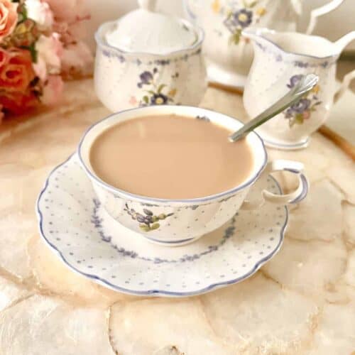 A cup of Royal Milk tea with a sugar caddy and milk jug behind.