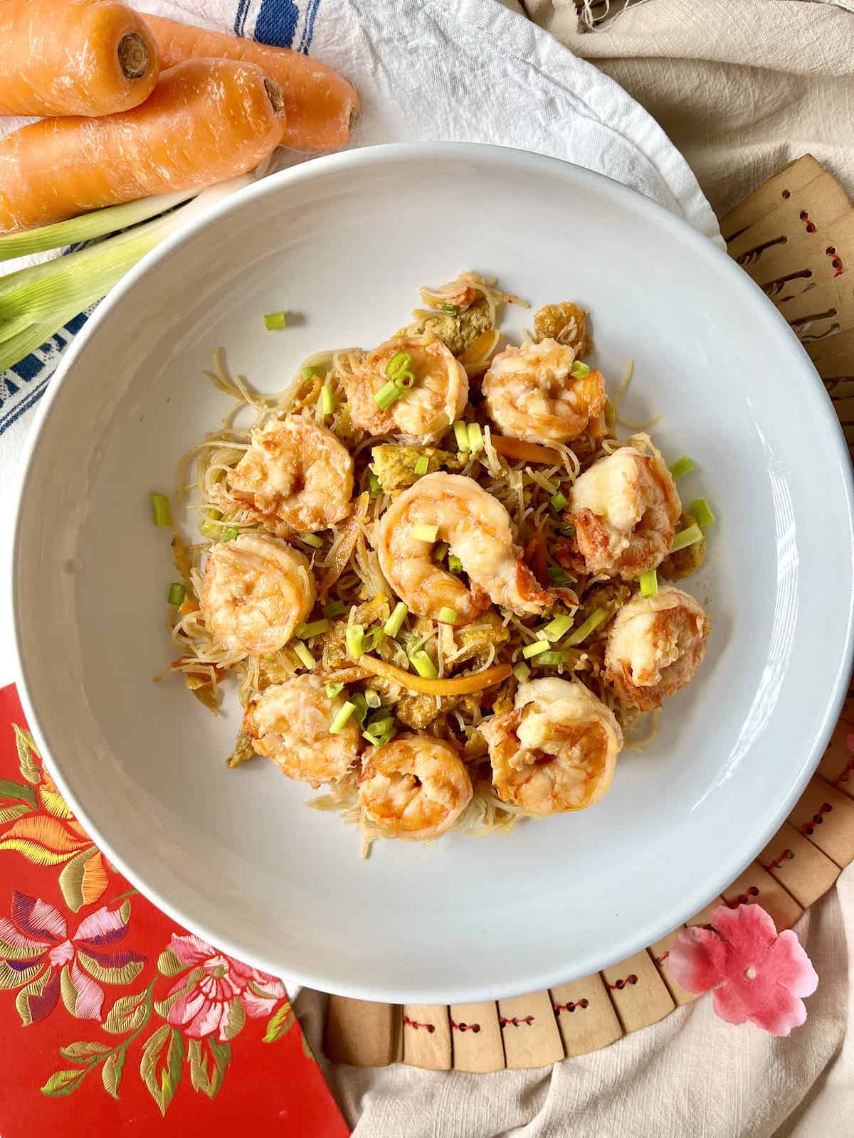 Thin Rice Vermicelli with lots of shrimp and scallions on a white plate.