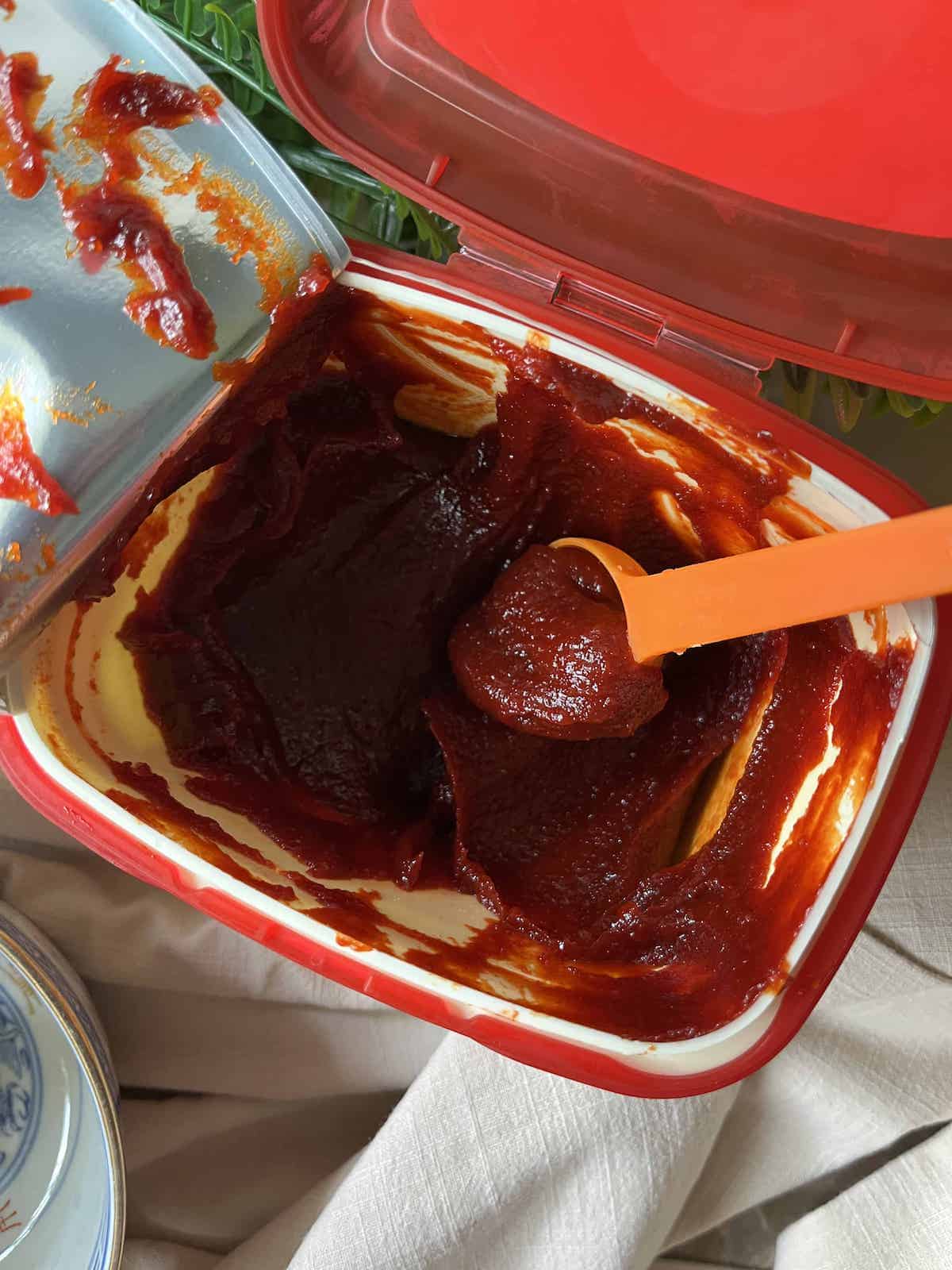 A tub of fresh thick gochujang red pepper paste.