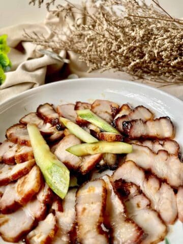 Close-up of a platter of Chinese BBQ pork and cucumbers.