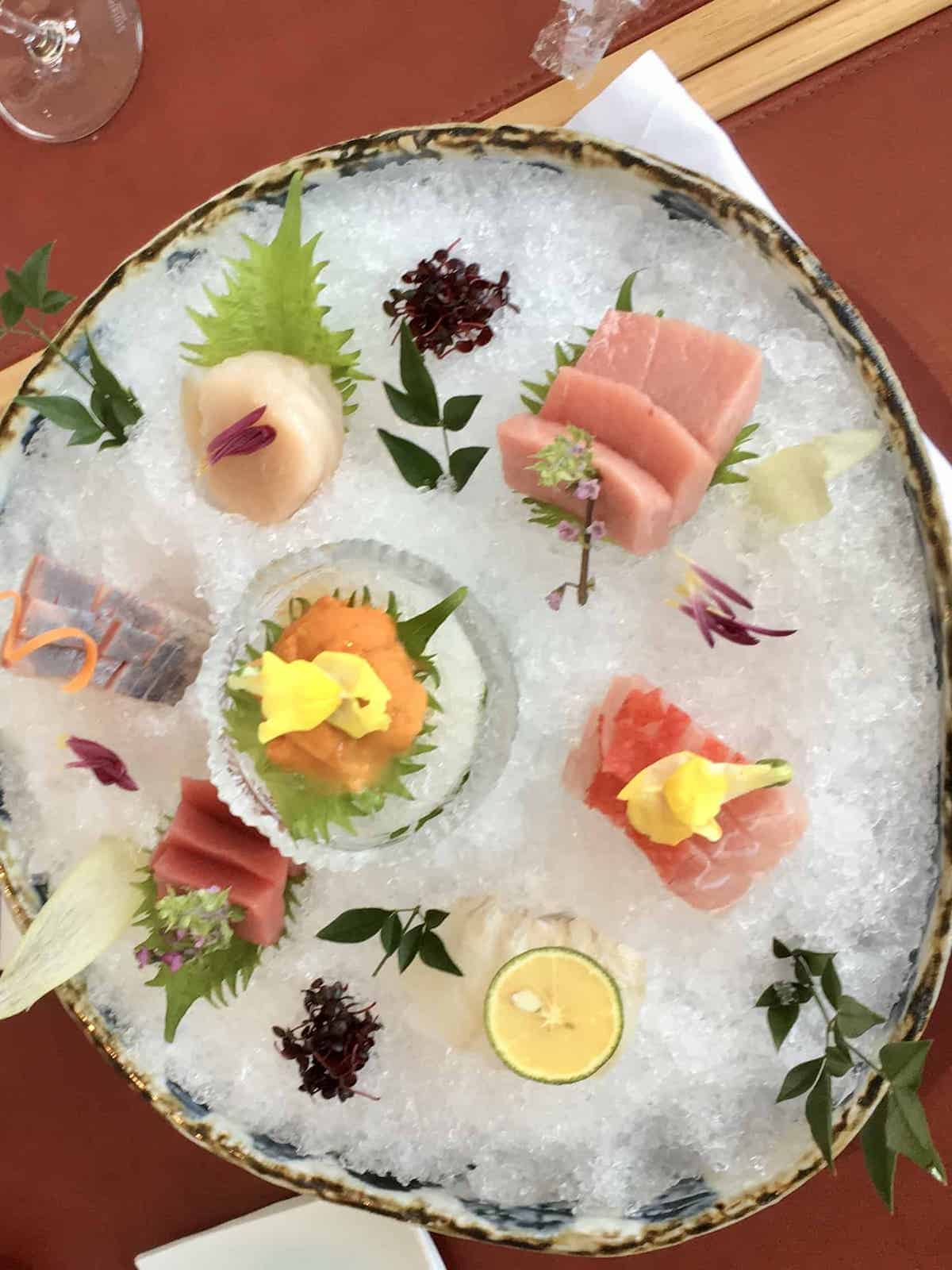 Slices of raw fish and sea urchin on ice.