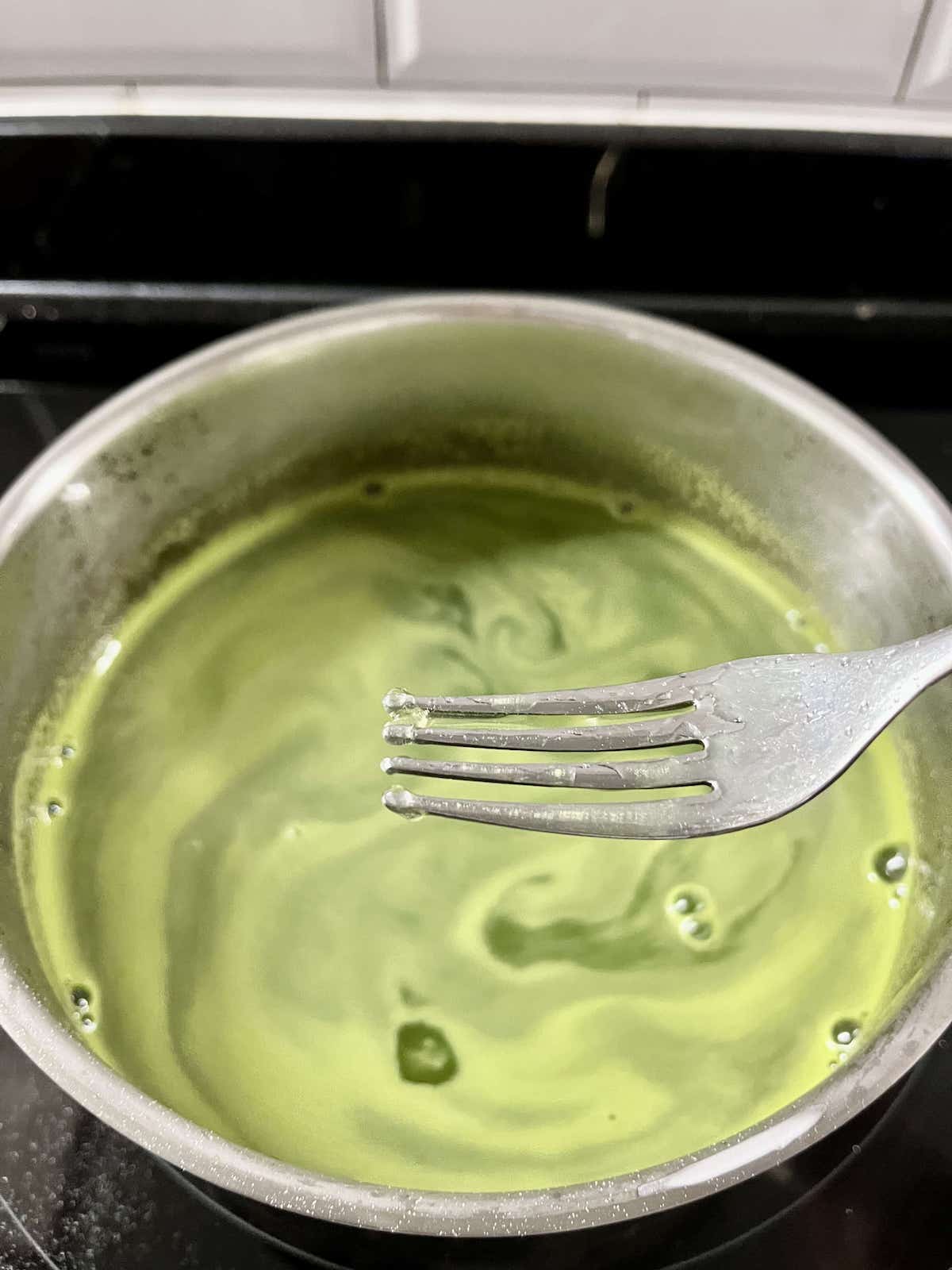 Close-up of agar agar jelly clumping around the tines of a fork.