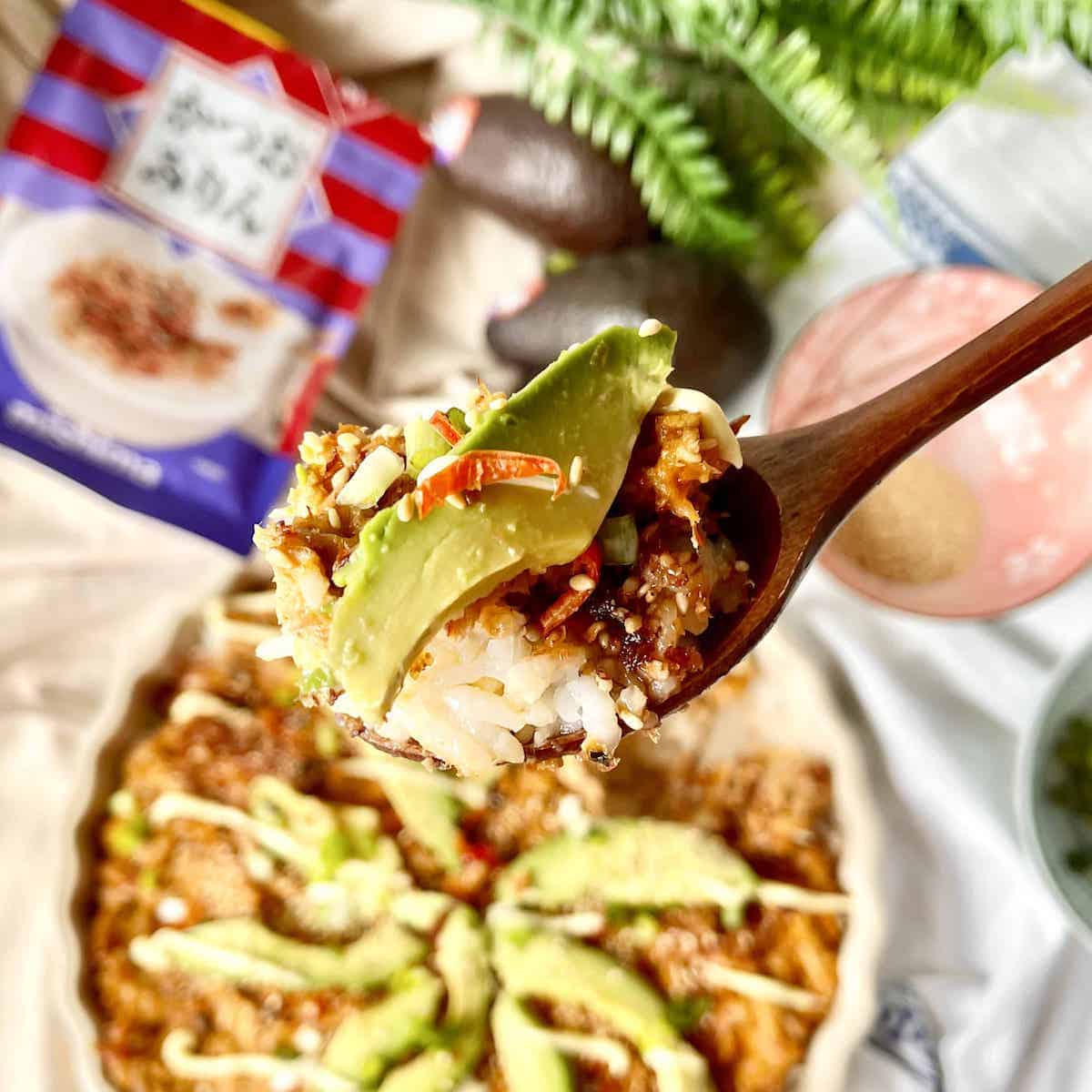 Close-up of a scoop of deconstructed sushi bake with avocado.