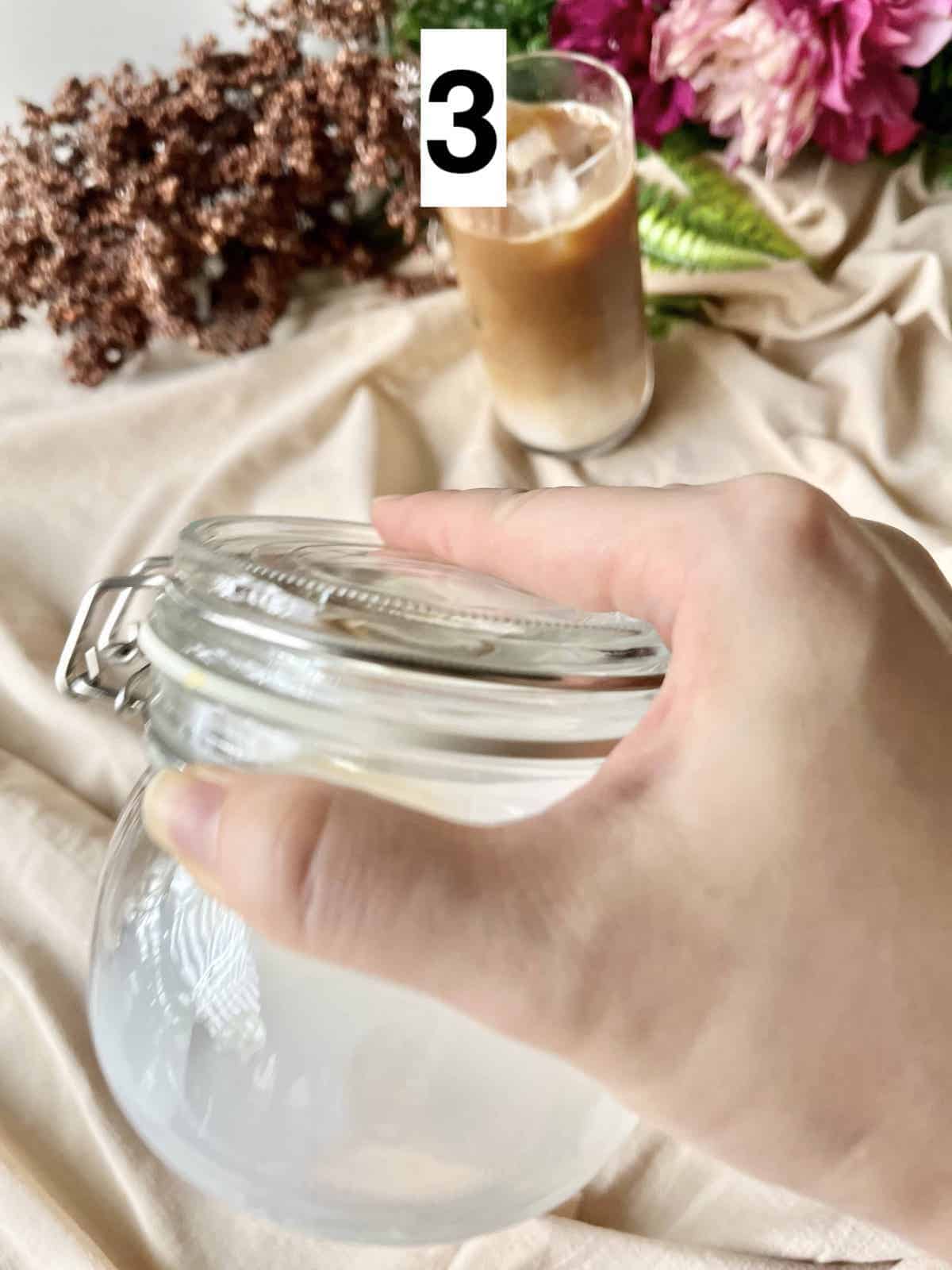 Shaking milk in a tightly sealed mason jar.