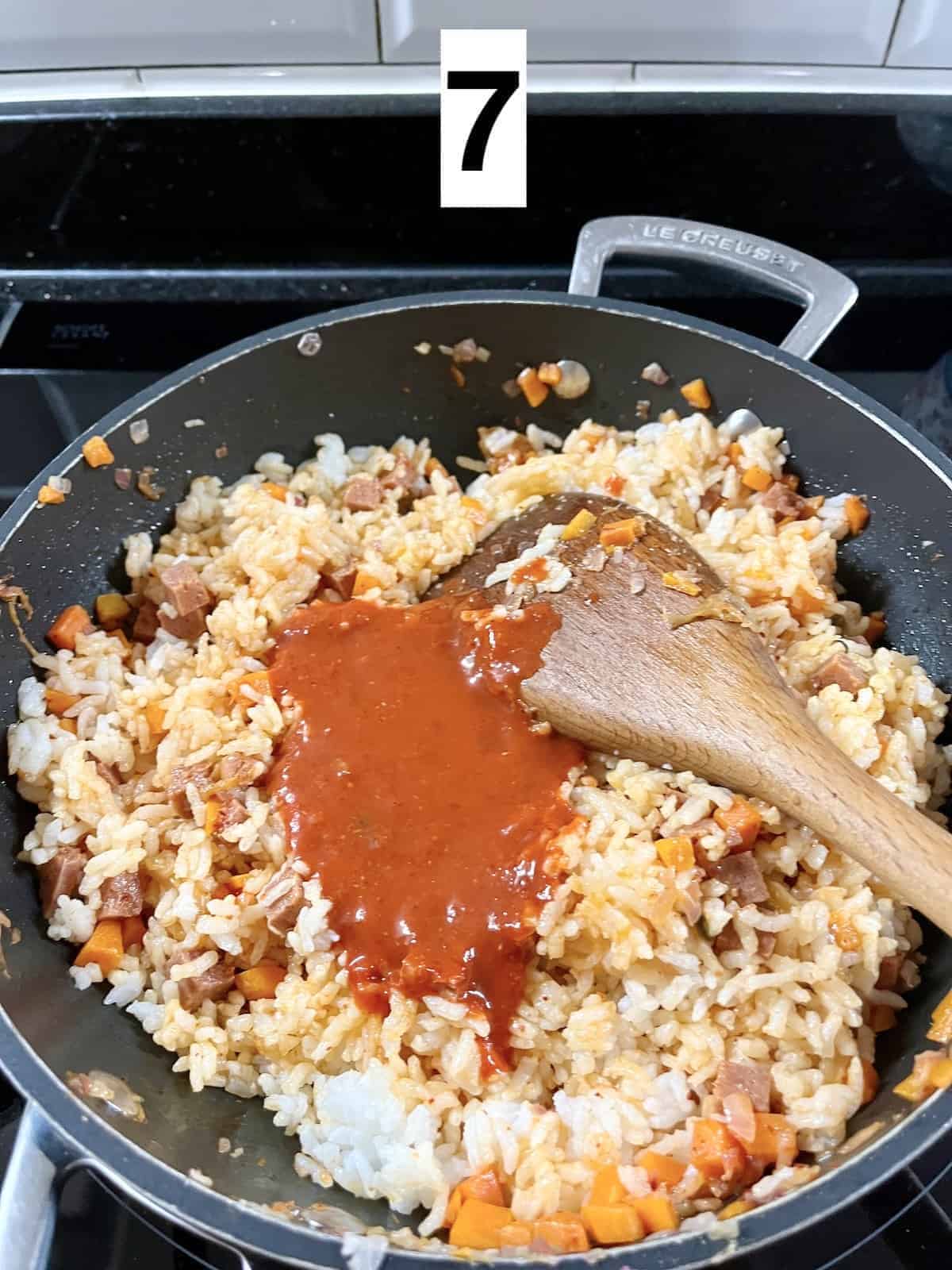 Mixing the gochujang and kimchi sauce into fried rice.