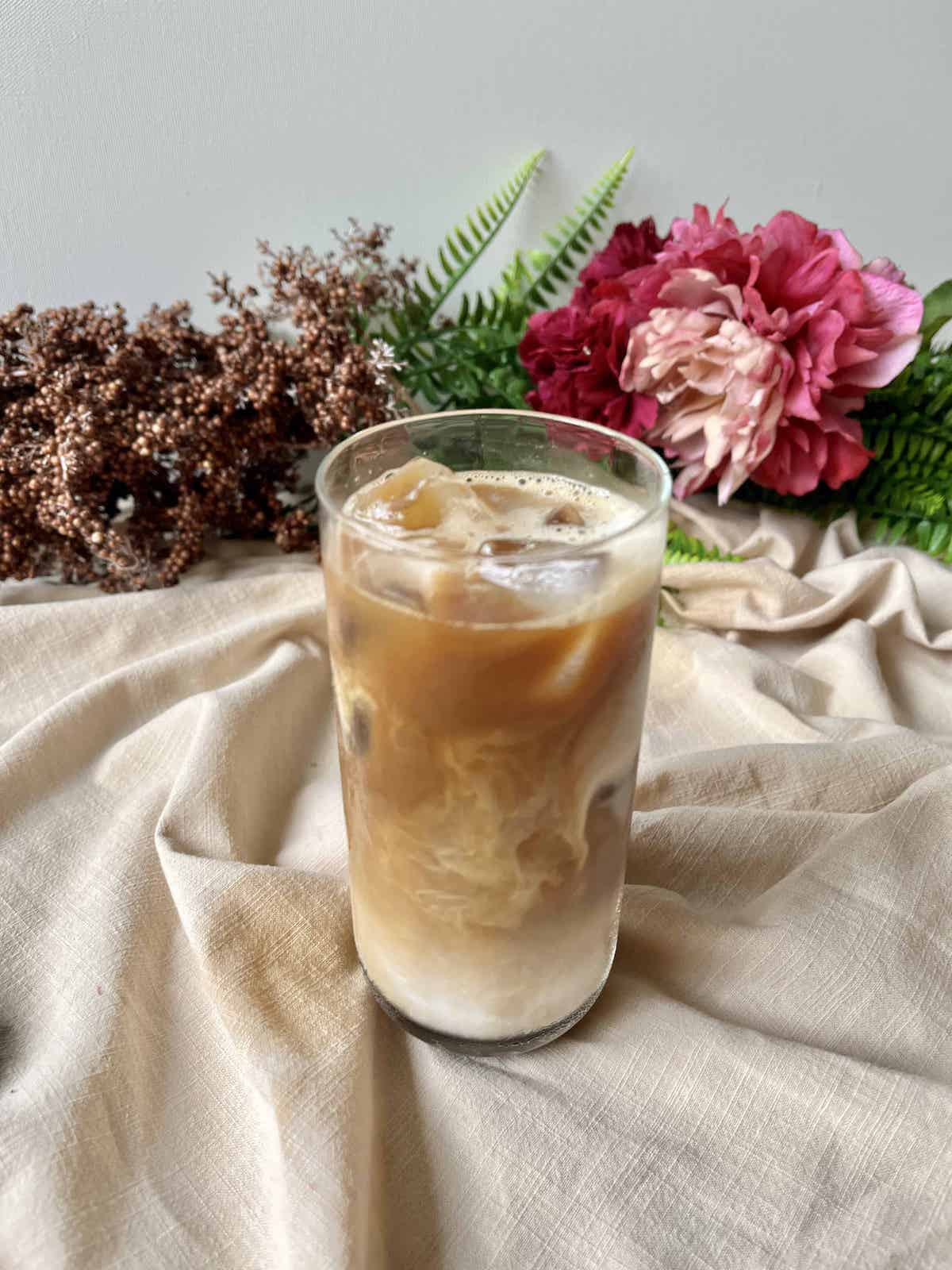 A glass of iced cold brew coffee with milk.