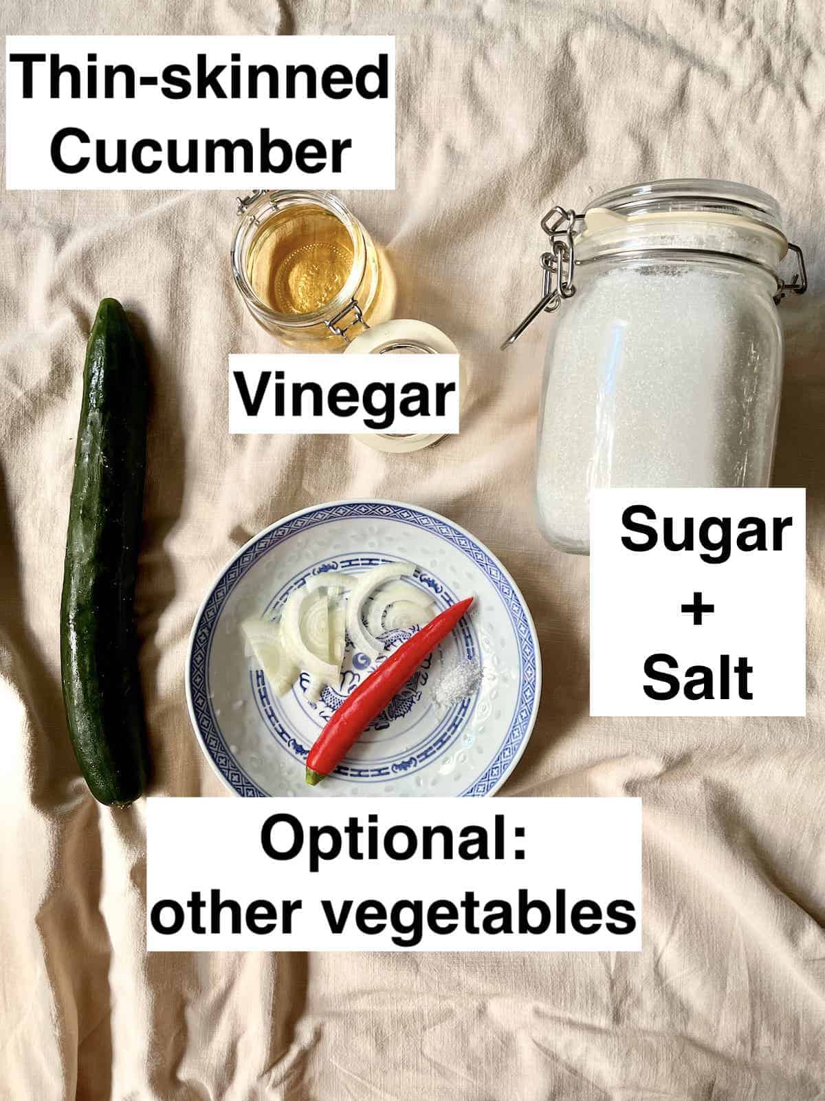 Cucumber, vinegar, sugar, salt, onions and chilis on a tablecloth.