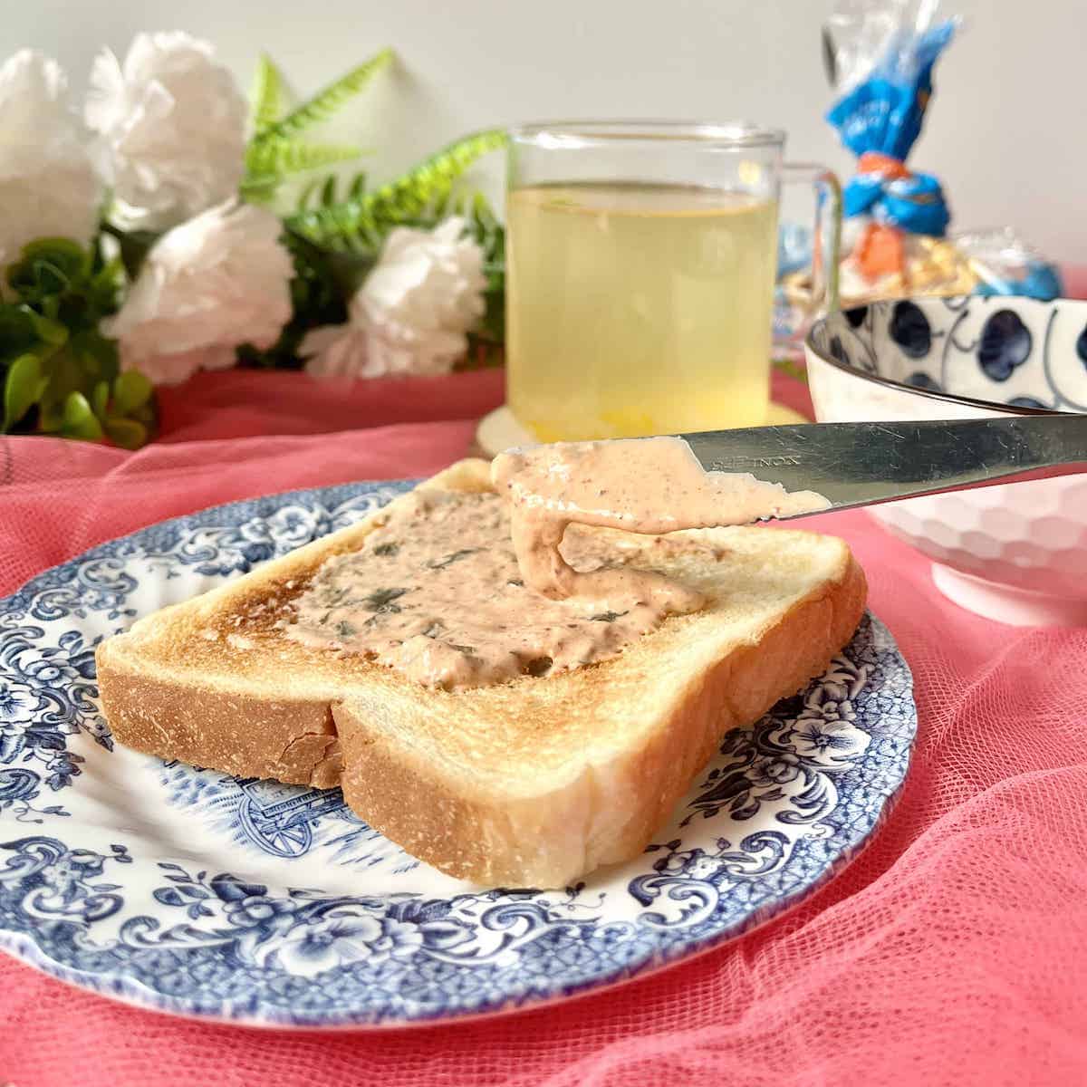 Korean Mayonnaise mixed with kimchi being spread on white toast.